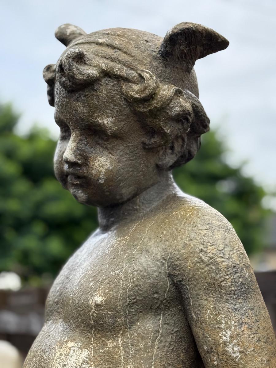 Large garden statue of putti on pedestal