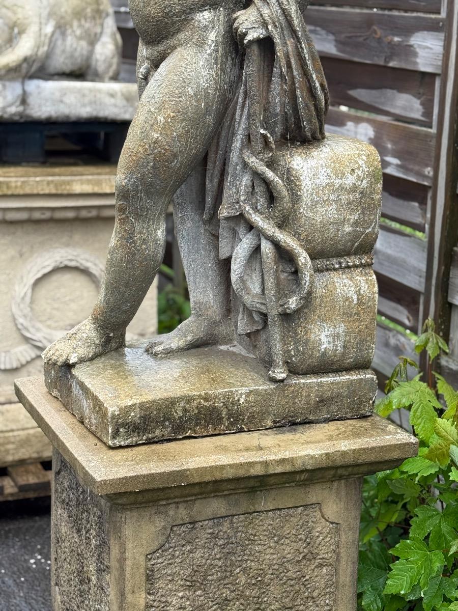 Large garden statue of putti on pedestal